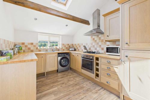 - une cuisine avec des placards en bois et un lave-vaisselle dans l'établissement Host & Stay - Easton Meadows Holiday Cottage, à Boynton