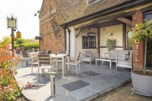a patio with tables and chairs in front of a building at The Chequers Inn in Beaconsfield
