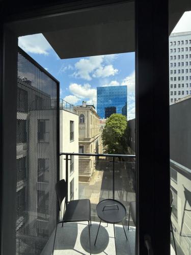 a balcony with chairs and a view of a city at ROOSEVELTA RESIDENCE Apartments - przy OFF Piotrkowska in Łódź