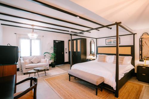 a bedroom with a canopy bed and a living room at Hotel Son Molí Country House in Playa de Palma