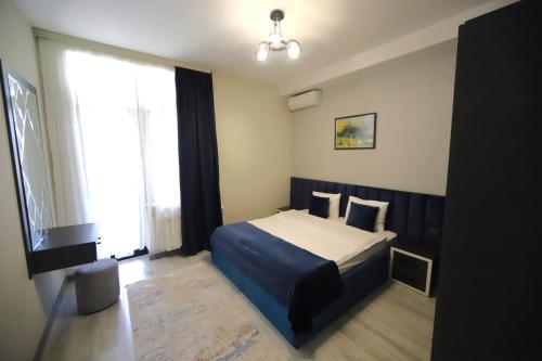 a bedroom with a bed and a large window at Passage Hotel in Baku