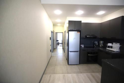 a kitchen with a white refrigerator and a hallway at Passage Hotel in Baku