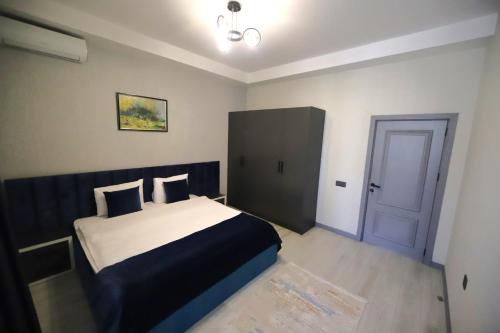 a bedroom with a bed and a blue door at Passage Hotel in Baku