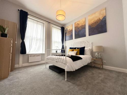 a bedroom with a white bed and a window at The Bournemouth Haven - Brought to you by Coastline Retreats - Grand 2 bedroom luxury apartment - 3 mins walk to beach - Superfast Wifi - Sleeps 6 in Bournemouth