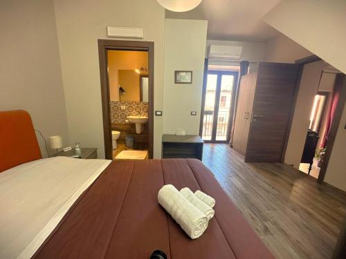 a bedroom with a bed with a pair of towels on it at Il Carro Comfortable Rooms in San Giovanni Gemini