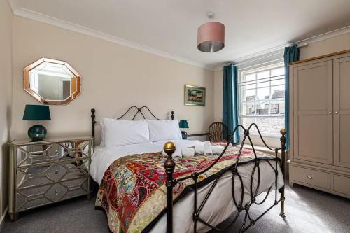a bedroom with a bed and a mirror at Margarets Buildings Bath City Centre in Bath
