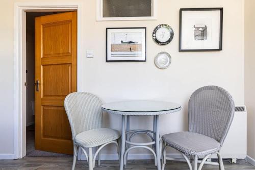 a table and two chairs and a clock on a wall at Margarets Buildings Bath City Centre in Bath