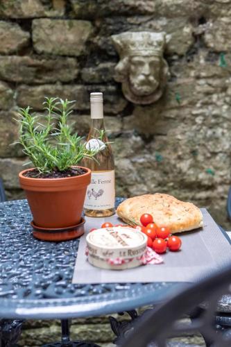 a table with a bottle of wine and a potted plant at Central, beautiful home - with parking in Bradford on Avon
