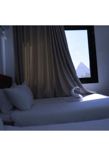 una camera con un letto e una finestra di Mass Of giza pyramids a Il Cairo