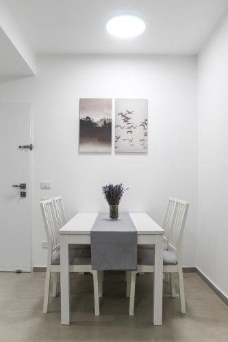 a white dining room with a white table and chairs at Luxury Suite Apartment #57 By Hashdera Eilat in Eilat