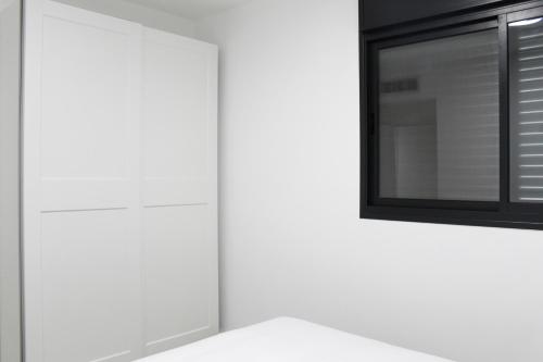 a kitchen with white cabinets and a mirror at Luxury Suite Apartment #57 By Hashdera Eilat in Eilat