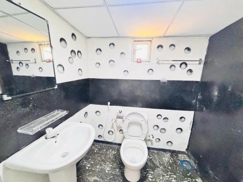 Un baño con un inodoro blanco y un lavabo. en Spl inn, en Trincomalee