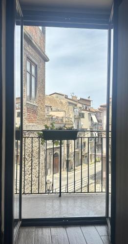 an open door to a balcony with a view of a building at Il Carro Comfortable Rooms in San Giovanni Gemini