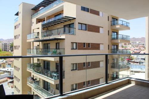 an apartment building with balconies on a balcony at Luxury Suite Apartment #57 By Hashdera Eilat in Eilat