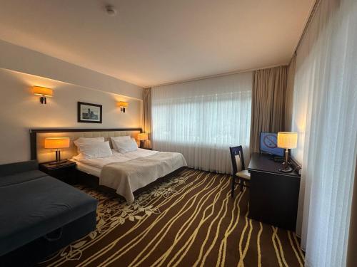 a hotel room with a bed and a window at Hotel Business Faltom Gdynia in Rumia