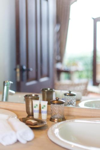 a bathroom counter with a sink and three cups on it at Ololo Safari Lodge & Farm in Nairobi