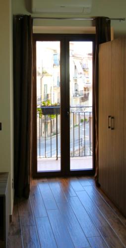 an empty room with an open door to a balcony at Il Carro Comfortable Rooms in San Giovanni Gemini