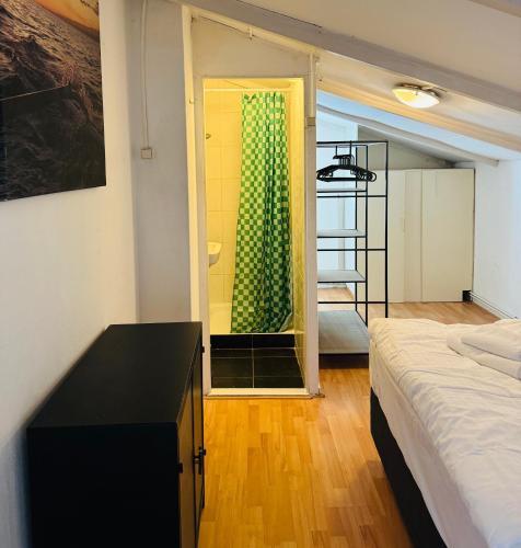 a bedroom with a bed and a bathroom with a shower at Het zandhuisje 84 in Noordwijk aan Zee