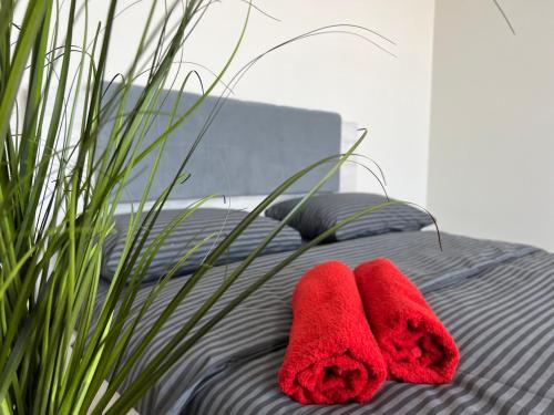 two red towels sitting on top of a bed at Апартаменти Замонастирська in Ternopilʼ
