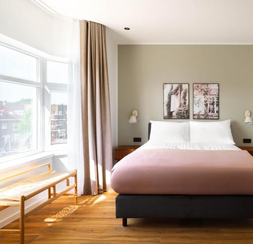 a bedroom with a large bed and a window at Limehome Utrecht Balijelaan in Utrecht