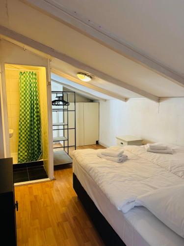 a bedroom with a large white bed and a window at Het zandhuisje 84 in Noordwijk aan Zee
