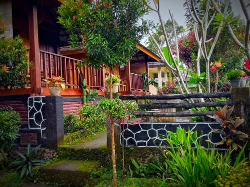 a garden with a bench in front of a house at Pondok rinjani bungalow tetebatu in Tetebatu