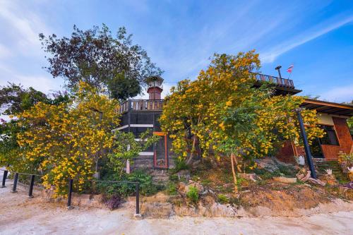 a house on a hill with trees in front of it at Baan Bonkao Resort Sattahip in Ban Khlot