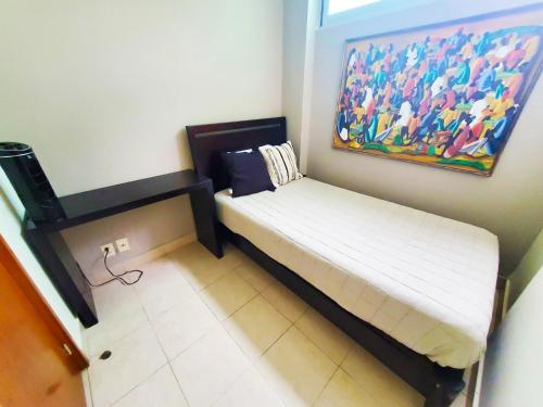 a small bed in a room with a painting on the wall at Departamento Mayan Lakes T9 - Albercas, club de playa, tenis, pádel y más in Acapulco
