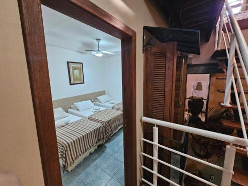 a view of a room with a bed and a mirror at GH Bizkaia in Florianópolis