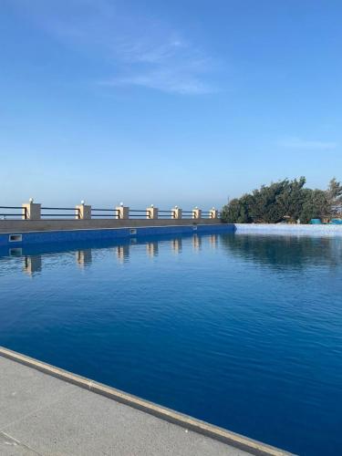 a large body of blue water with benches in the background at Style Home Buzovna in Baku