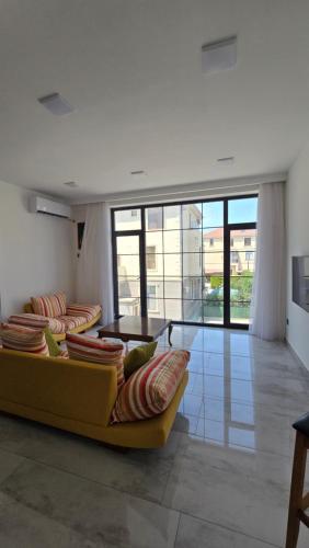 a living room with couches and a table and windows at Style Home Buzovna in Baku