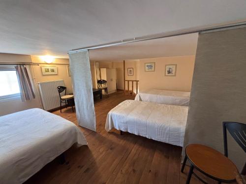 une chambre d'hôtel avec deux lits, une table et des chaises dans l'établissement En Avignon 30133 les Angles, aux Angles (Gard)