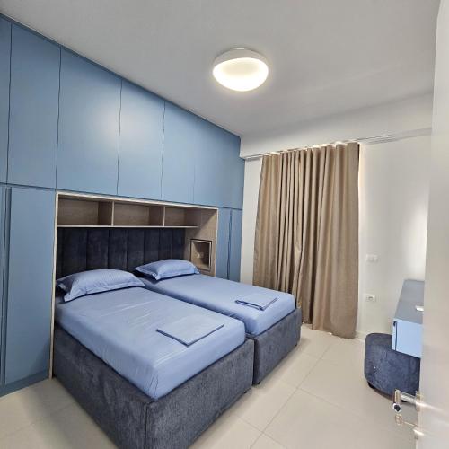 ein Schlafzimmer mit einem großen Bett mit einer blauen Wand in der Unterkunft Blue Horizon And Seaside Serenity in Sarandë