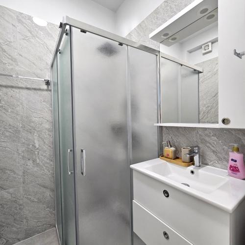 ein Badezimmer mit Dusche und Waschbecken in der Unterkunft Blue Horizon And Seaside Serenity in Sarandë