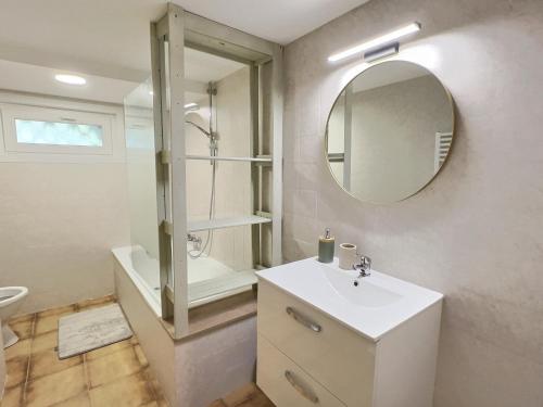 Un baño blanco con lavabo y espejo. en Appartement LE 33, en Hombourg-Haut