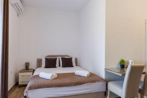 a small bedroom with a bed and a chair at Apartments Donna in Bar