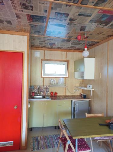 a kitchen with a red door and a table at Guest House Serena in Chornomorsk
