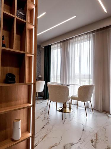 a room with chairs and a table and a window at Airport SkyLuxe Luxury Residence - Private Parking in Cluj-Napoca