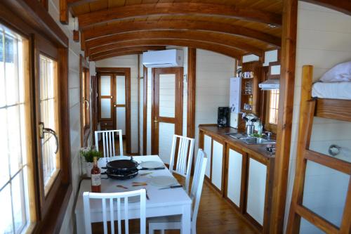 - une cuisine avec une table et des chaises dans une petite maison dans l'établissement La Roulotte Espérance, à Méaudre