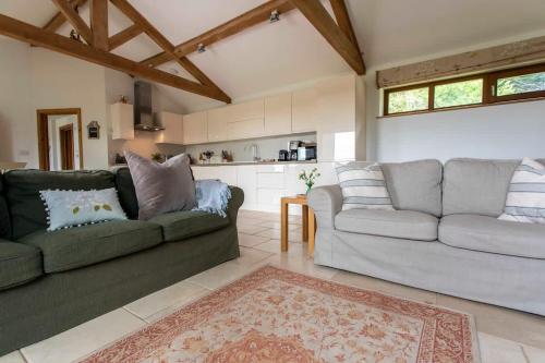 a living room with two couches and a kitchen at Beautiful Box Hill Lodge in Box