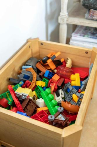 a wooden box filled with legos and other toys at Beautiful Box Hill Lodge in Box