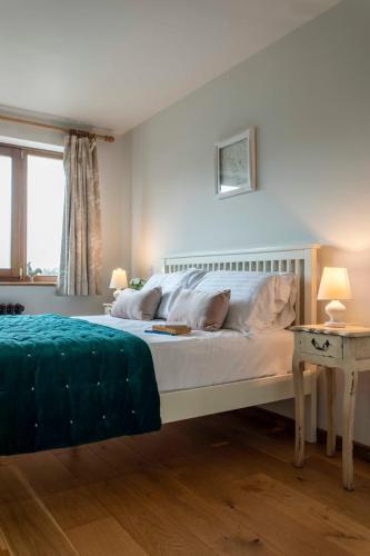 a bedroom with a large bed with white sheets and pillows at Beautiful Box Hill Lodge in Box