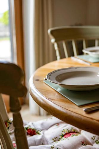 a wooden table with a plate on top of it at Beautiful Box Hill Lodge in Box