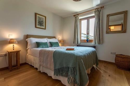 a bedroom with a bed with a green blanket on it at Beautiful Box Hill Lodge in Box