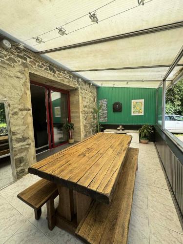 - une table en bois sur la terrasse d'une maison dans l'établissement Maison en pierre, à Trémeven