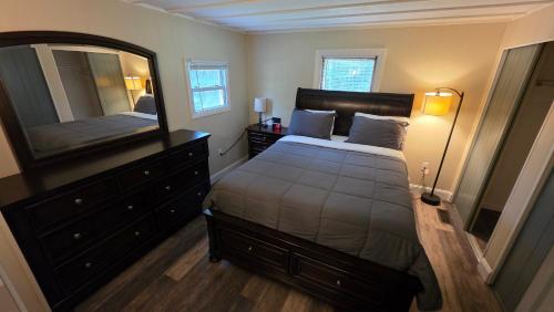 a bedroom with a bed and a dresser and a mirror at Abbot Trailside Lodging in Abbot Village