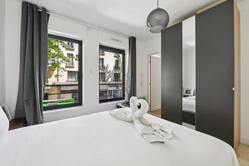 a bedroom with a white bed with a large window at Résidence AURMAT - Appart - Hôtel - Boulogne - Paris in Boulogne-Billancourt