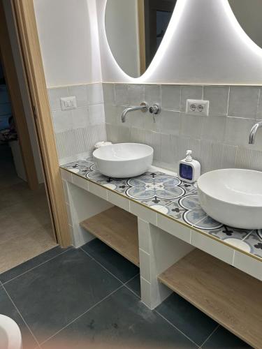 a bathroom with two sinks and a mirror at Casa Rosalia in Cozze