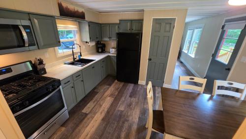 a kitchen with white cabinets and a black refrigerator at Abbot Trailside Lodging in Abbot Village