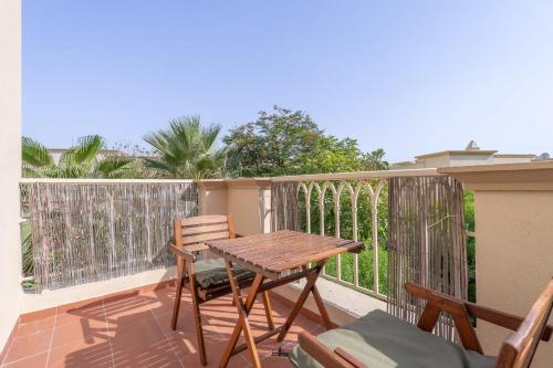 a wooden table and chairs on a balcony at Free housekeeping visits during your stay - StayShort - Vibrant Villa in Springs 11 Sleeps 6 with Balcony in Dubai
